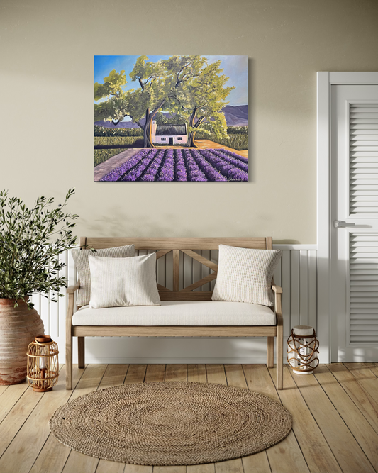 Painting of a lavender field with a house on a wall above a wooden bench.